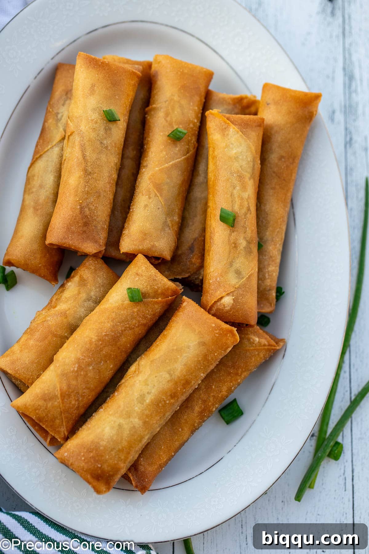 Savory Beef Spring Rolls 4 Crispy fried spring rolls with beef on a plate, ready to be served.