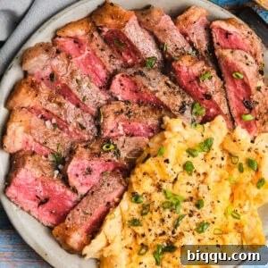 Close-up of Steak and Scrambled Eggs on a plate.