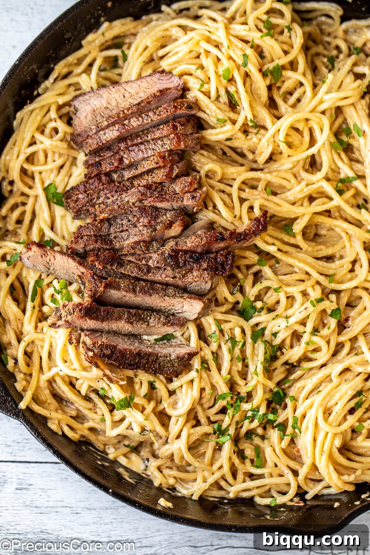 Finished Steak and Pasta dinner plated in a skillet, ready to serve.