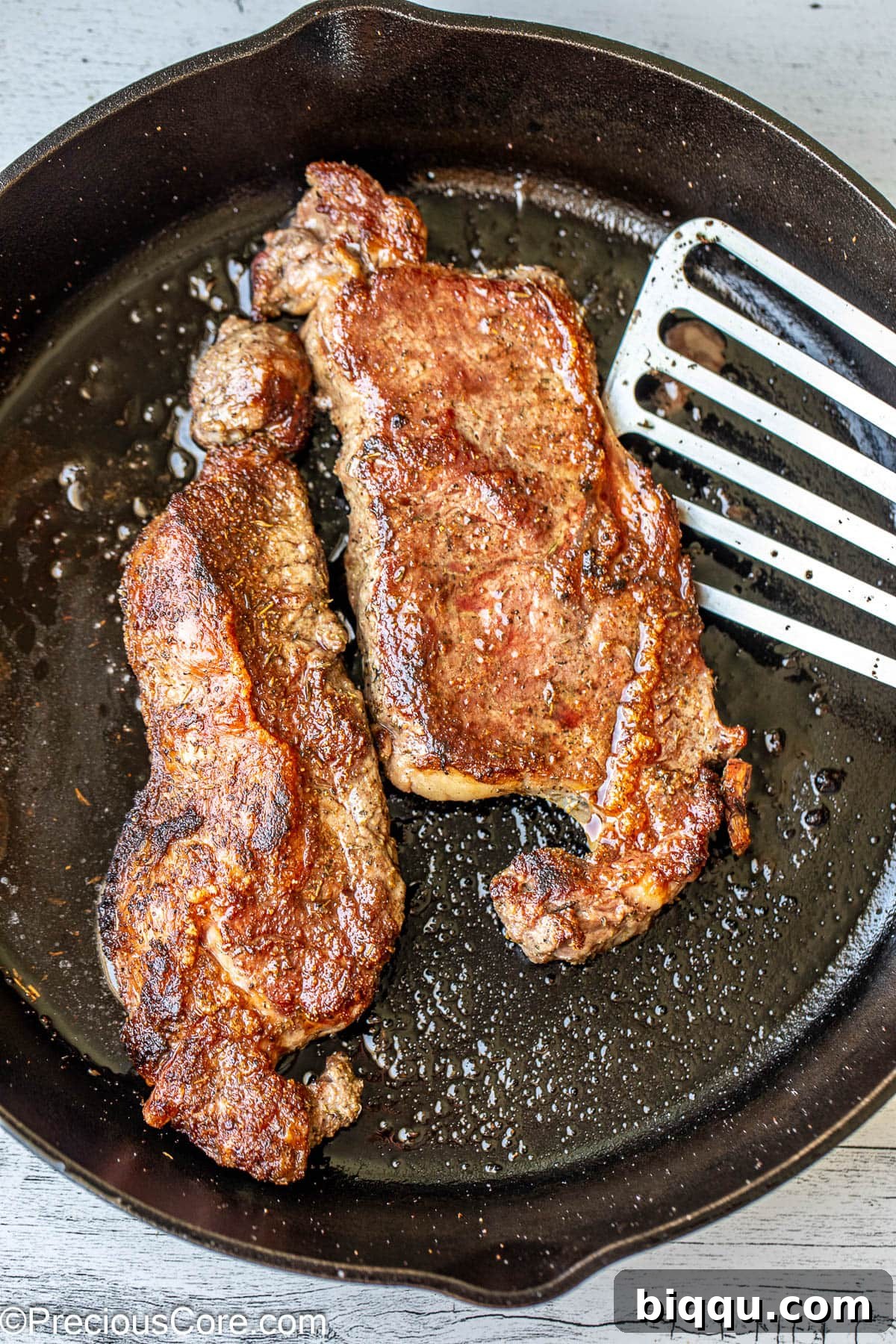 Searing steaks in a hot skillet with olive oil.