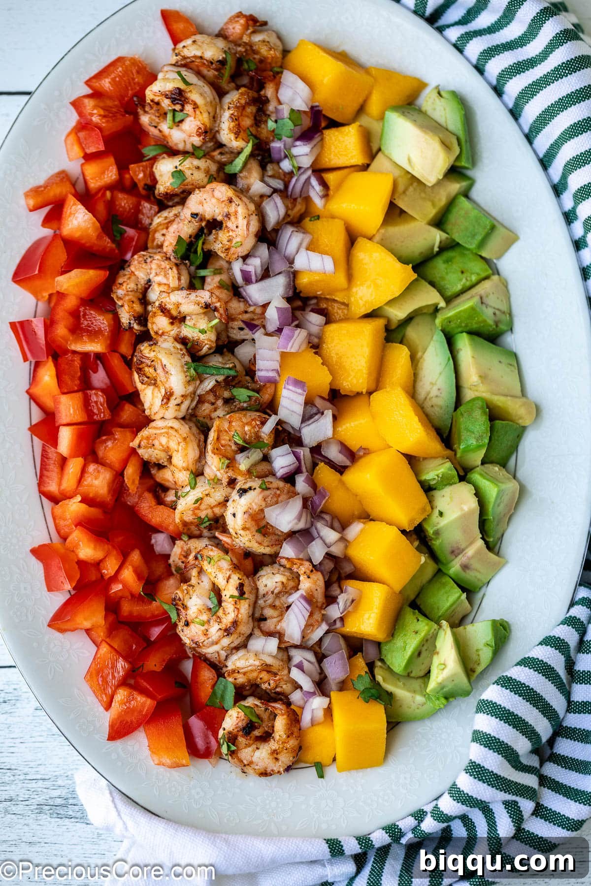 Vibrantly diced mango, perfectly cooked shrimp, creamy avocado, and colorful bell peppers ready to be tossed into a refreshing salad.