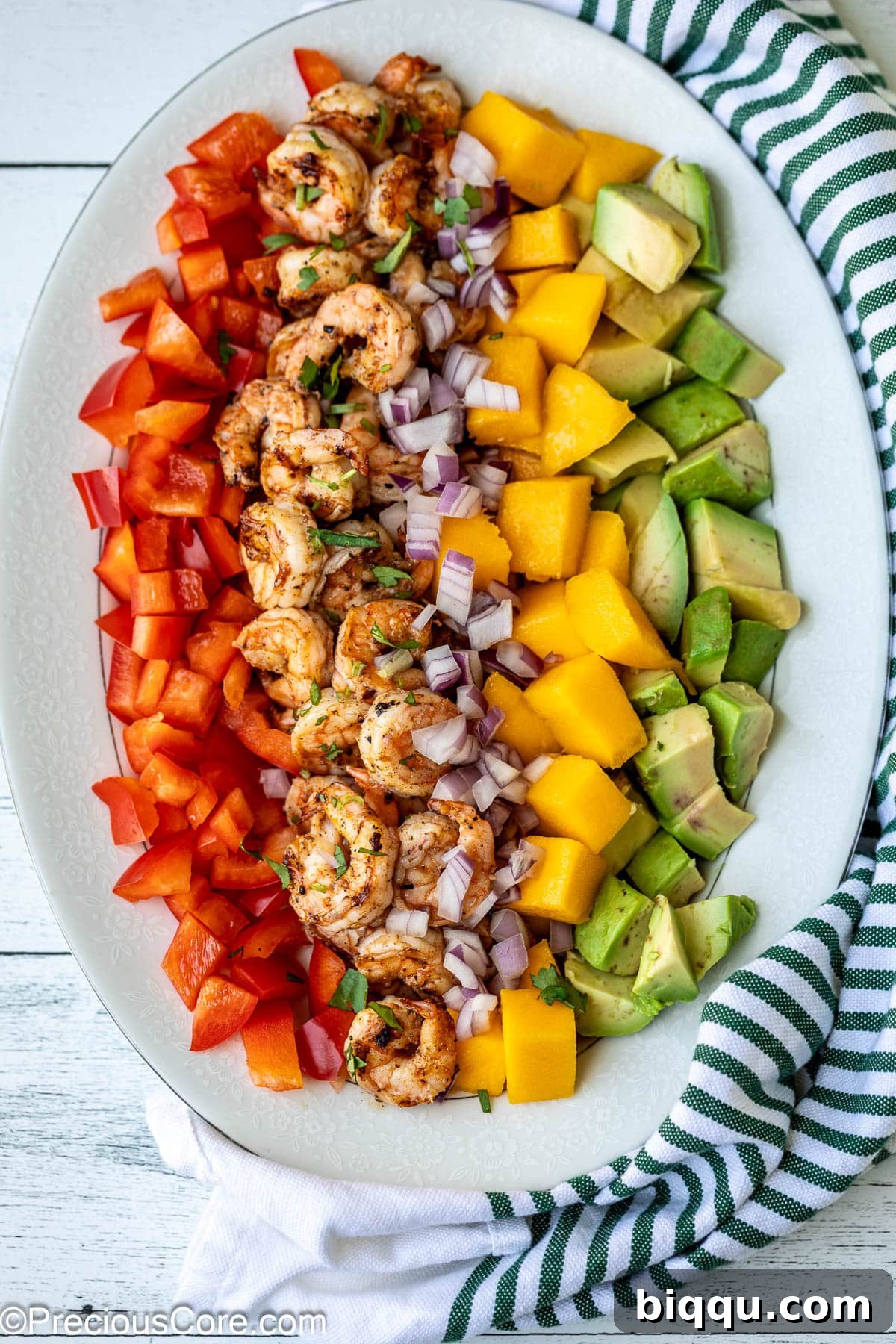 All the vibrant ingredients for Mango Avocado Salad, including cooked shrimp, diced mango, avocado, bell pepper, and red onion, artfully arranged on a platter.