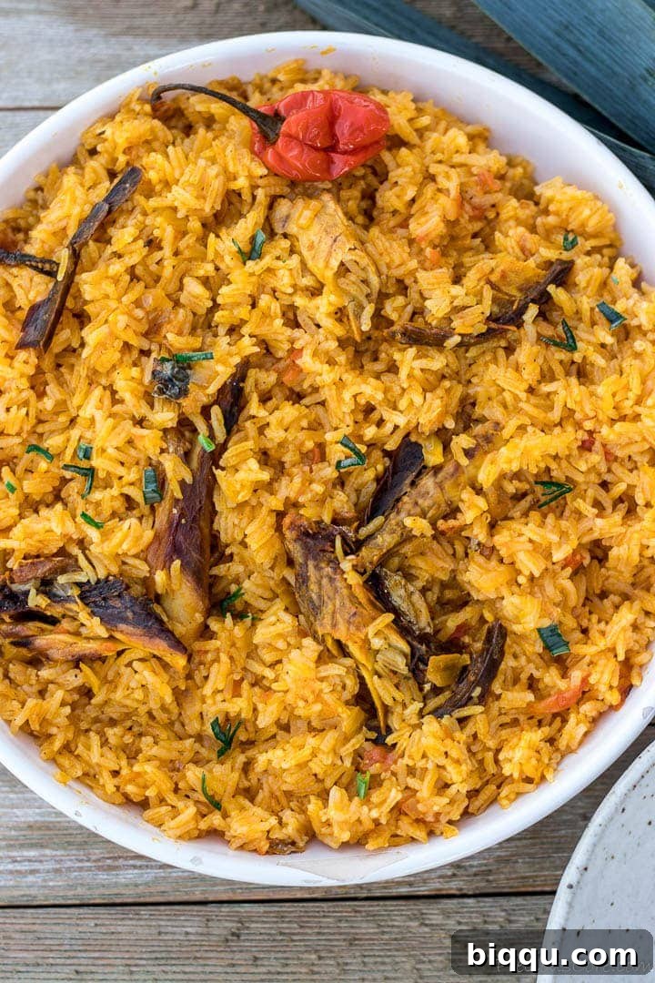 Close up of Cameroonian Njanga Rice, showcasing its rich reddish-orange color and enticing texture.