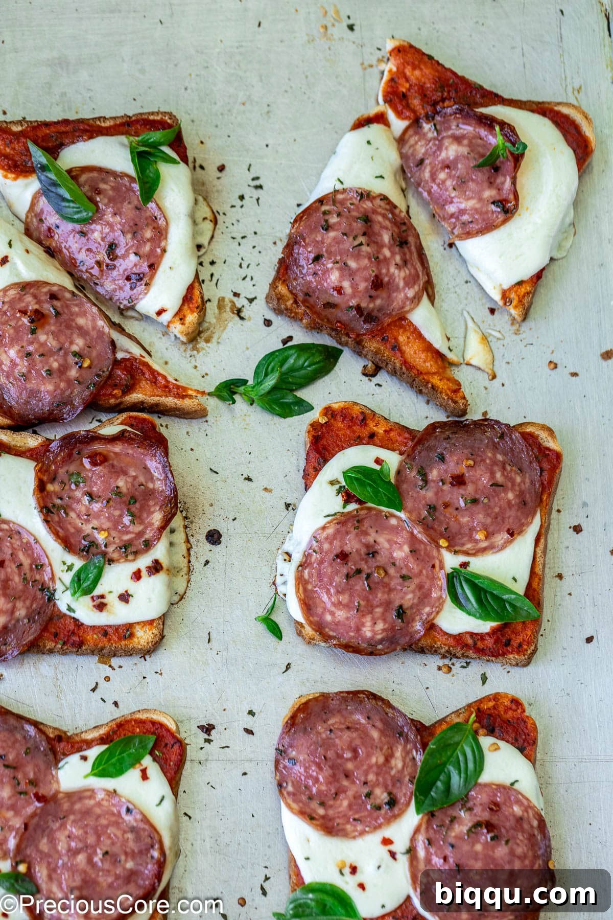 Crispy pizza toast garnished with fresh basil, ready to serve.