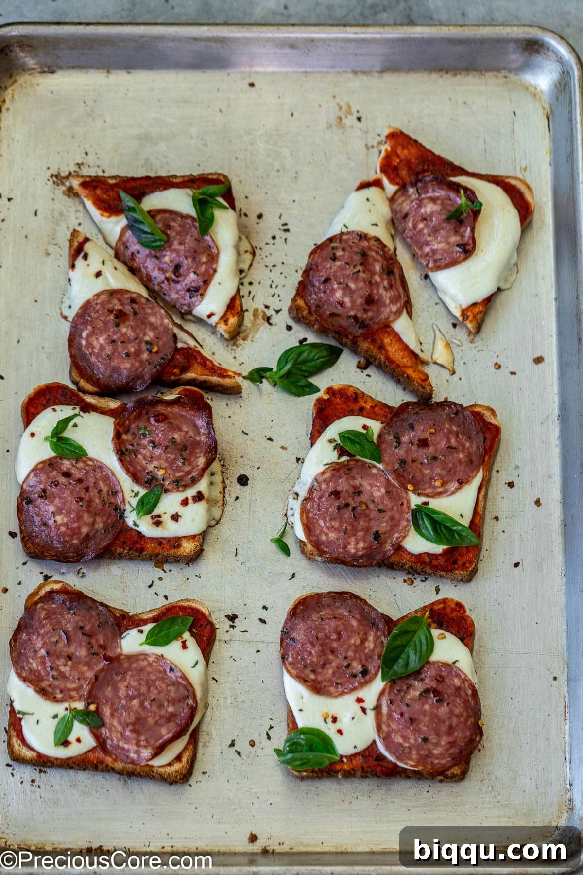Crispy pizza toasts cut into triangles on a wooden board, ready for sharing.