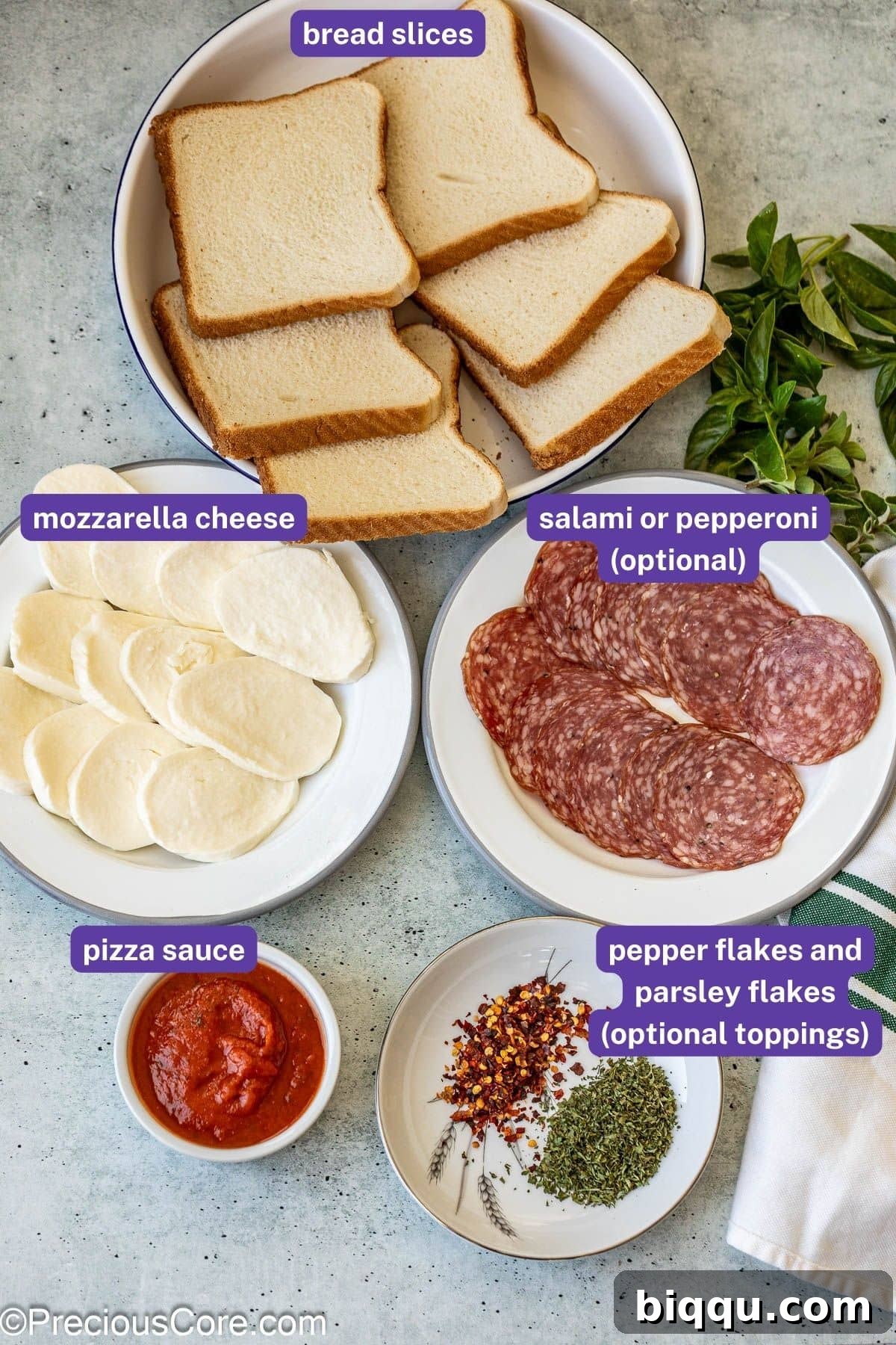 An assortment of fresh ingredients laid out for making pizza toast, including bread, sauce, cheese, and pepperoni.