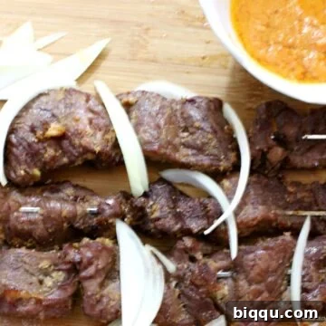 Cameroonian soya on a cutting board with onions.