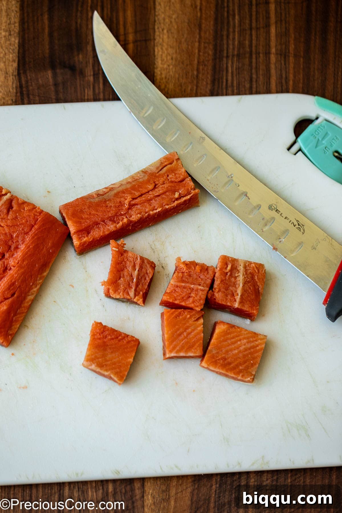 Cutting salmon into bite-sized pieces for Cajun pasta.