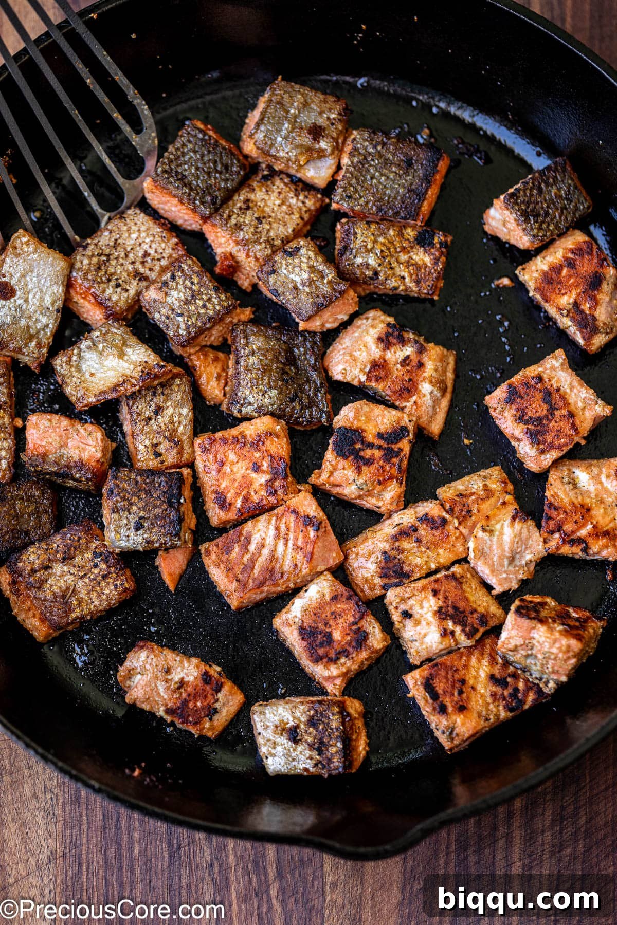 Cooking salmon pieces in a large skillet over medium-high heat.
