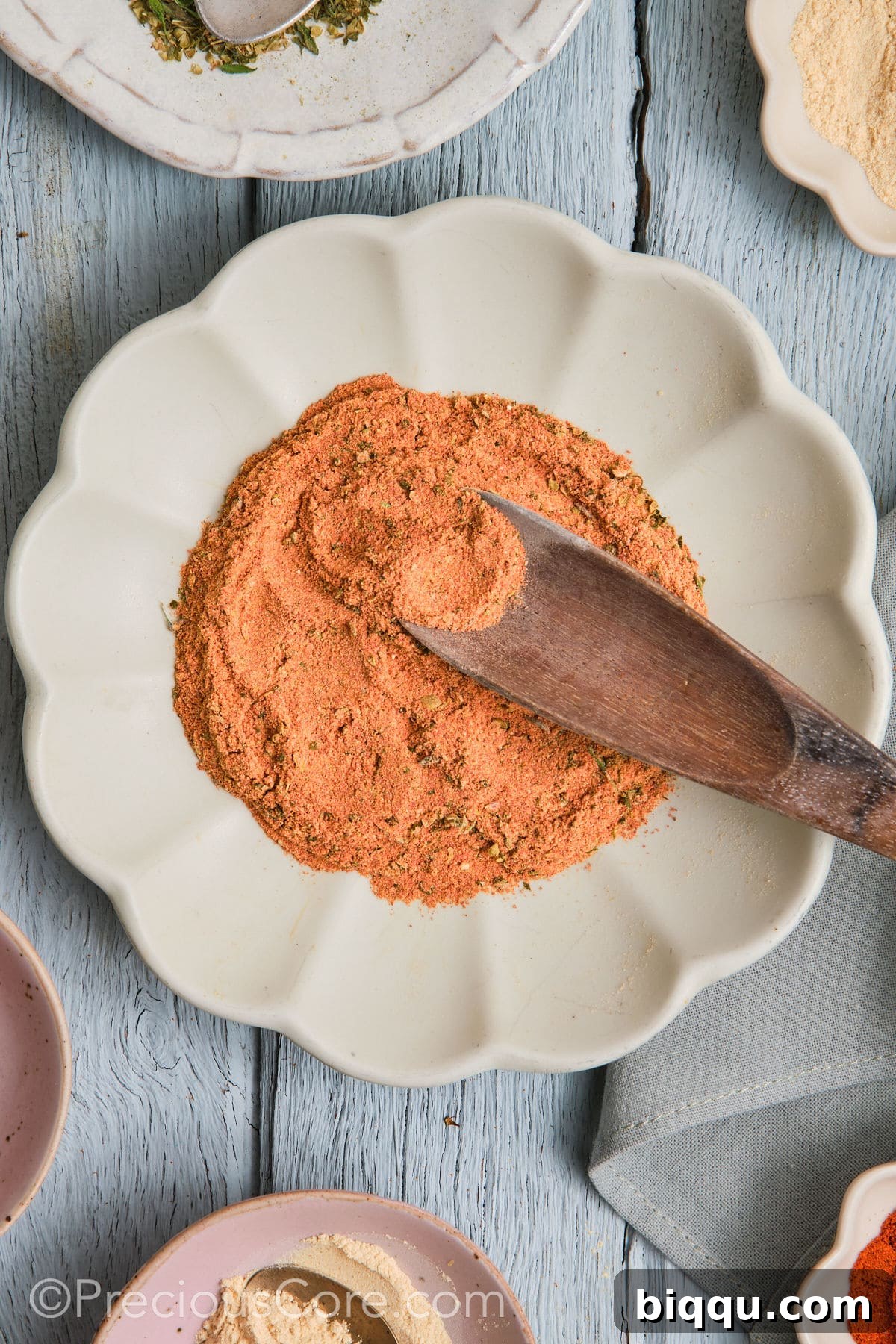 Wooden spoon in a plate of Cajun seasoning substitute.