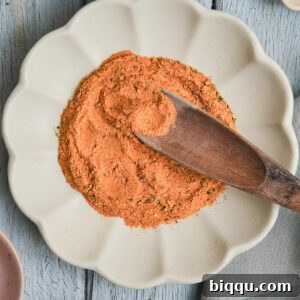 Wooden spoon in a plate of Cajun seasoning substitute.