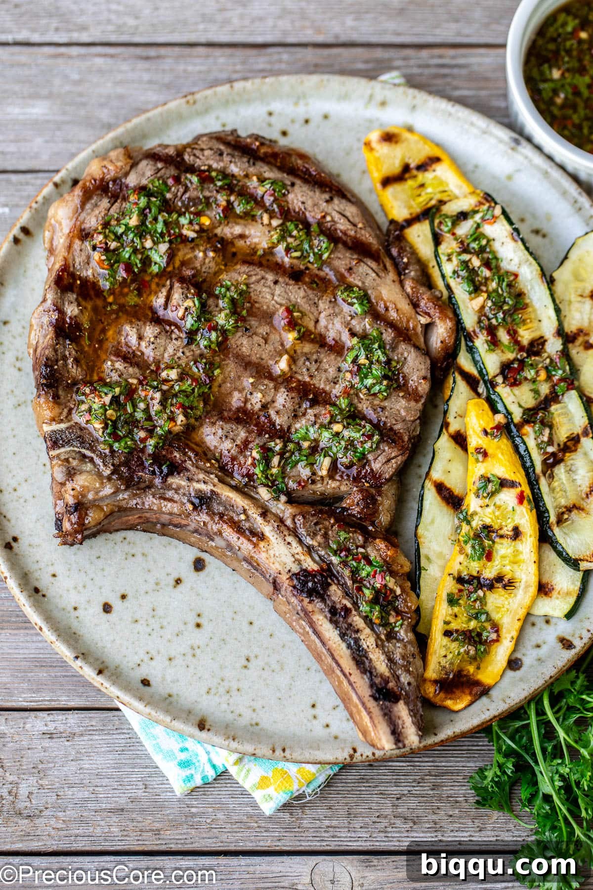 Bone-In Ribeye steak on a plate served with grilled zucchini.
