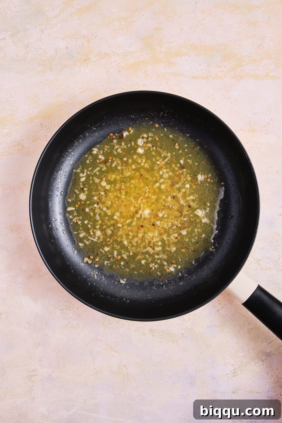 Zesty Lemon Garlic Butter Pasta 13 Cooked garlic butter sauce simmering in a skillet, ready for pasta.