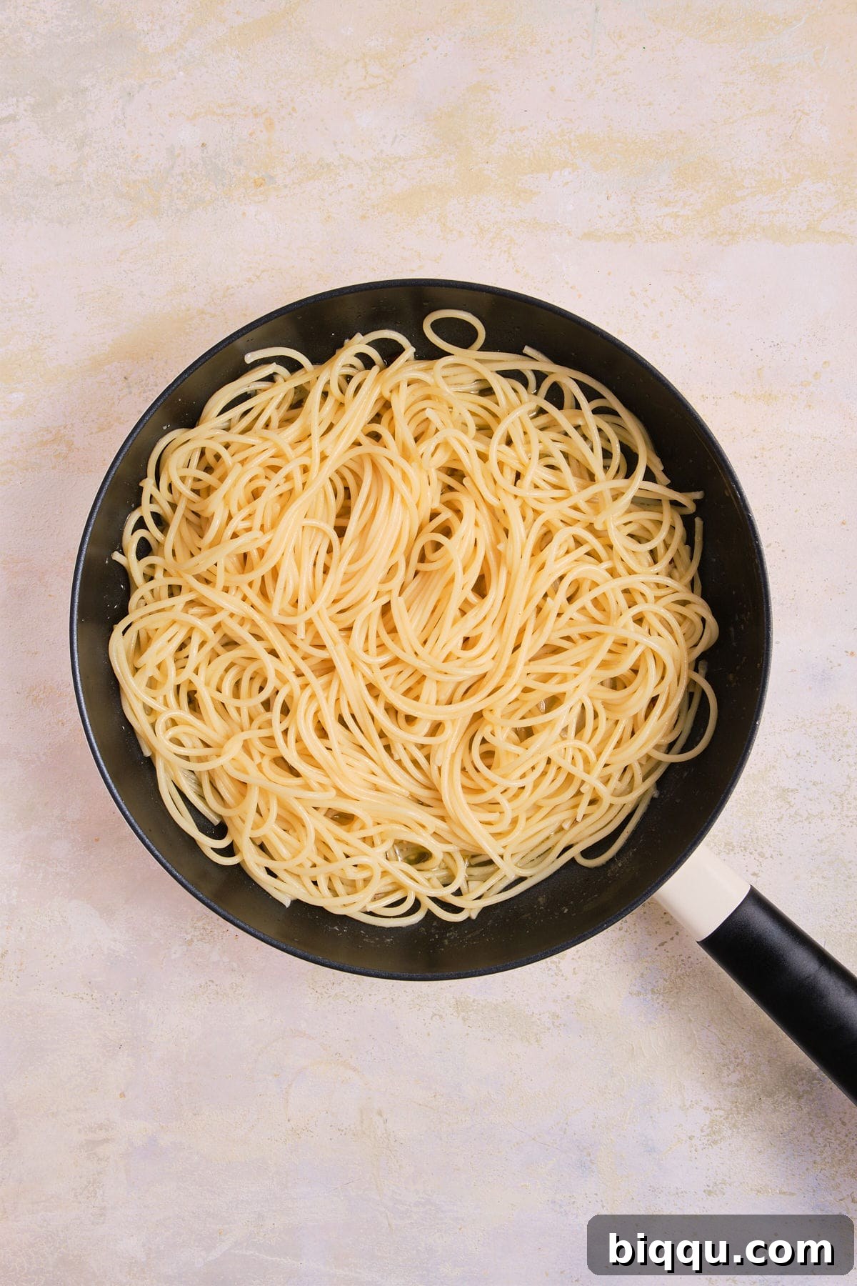 Zesty Lemon Garlic Butter Pasta 14 Cooked pasta being added to the skillet with garlic butter sauce.