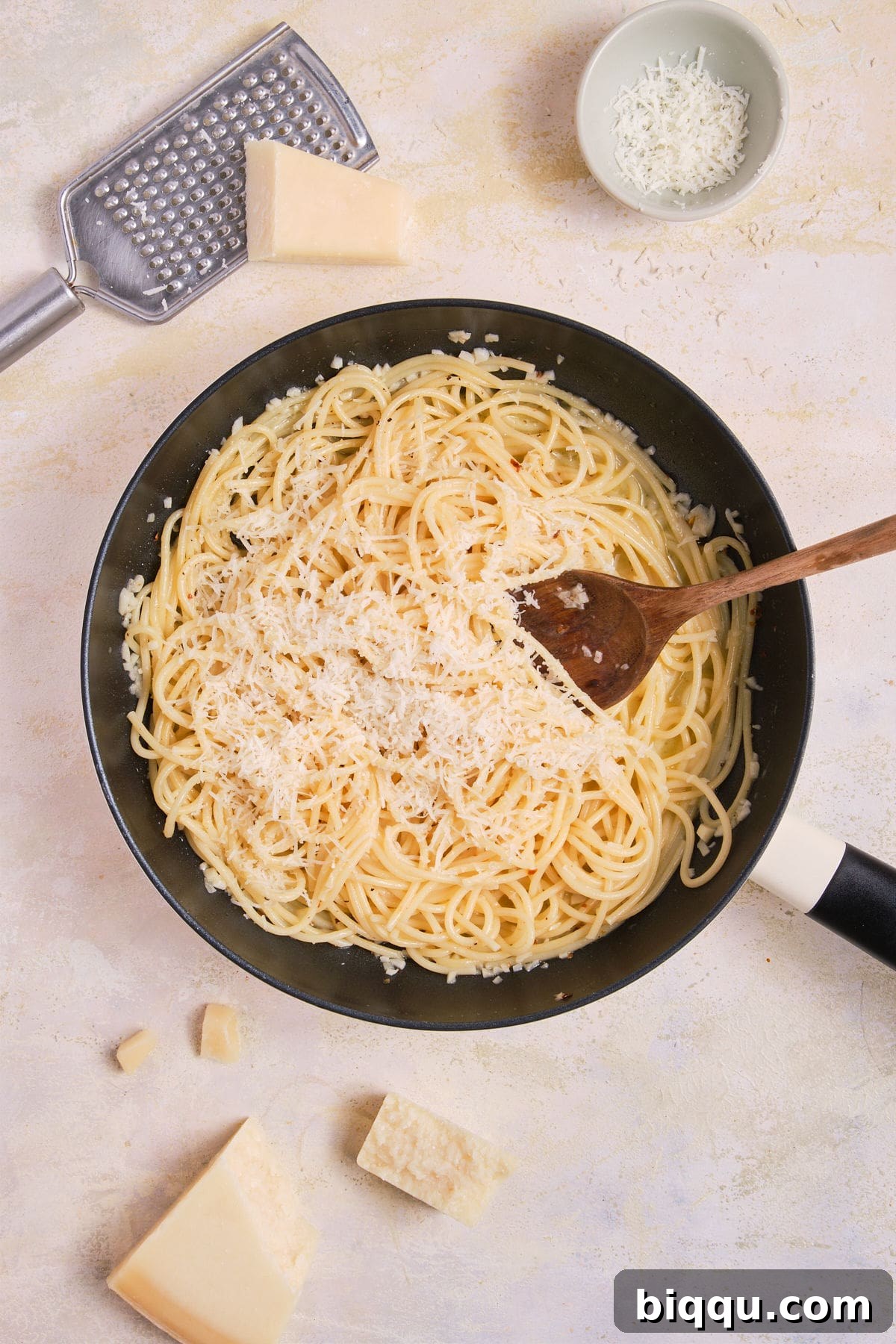 Zesty Lemon Garlic Butter Pasta 15 Parmesan cheese being added to the Lemon Garlic Butter Pasta in the skillet.