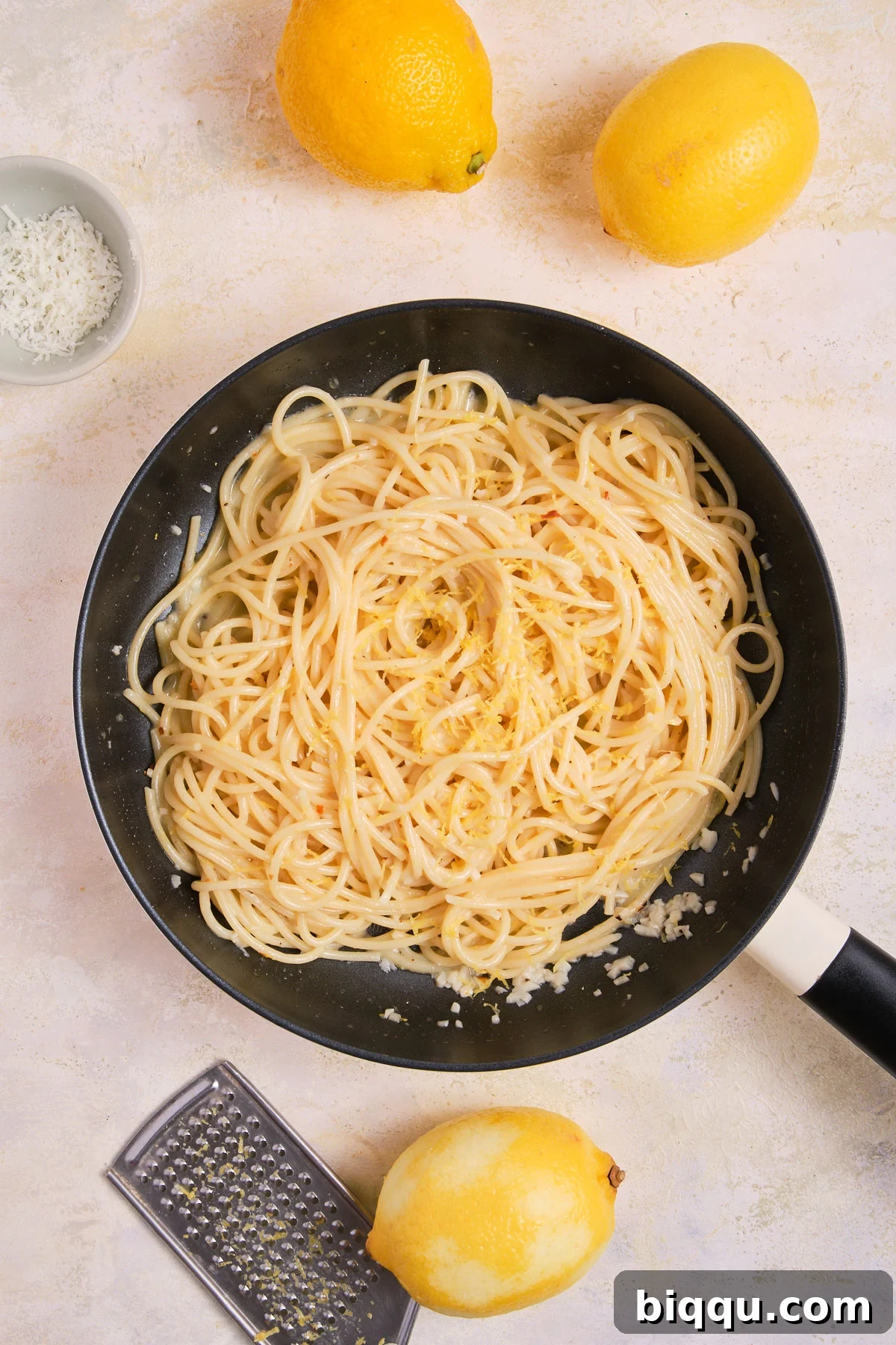 Zesty Lemon Garlic Butter Pasta 16 Fresh lemon zest being added to a pan of hot pasta.