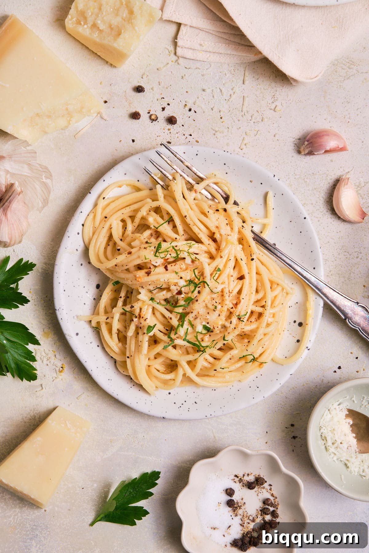 Zesty Lemon Garlic Butter Pasta 4 Pasta on a plate with fresh lemons, garlic, and herbs nearby.