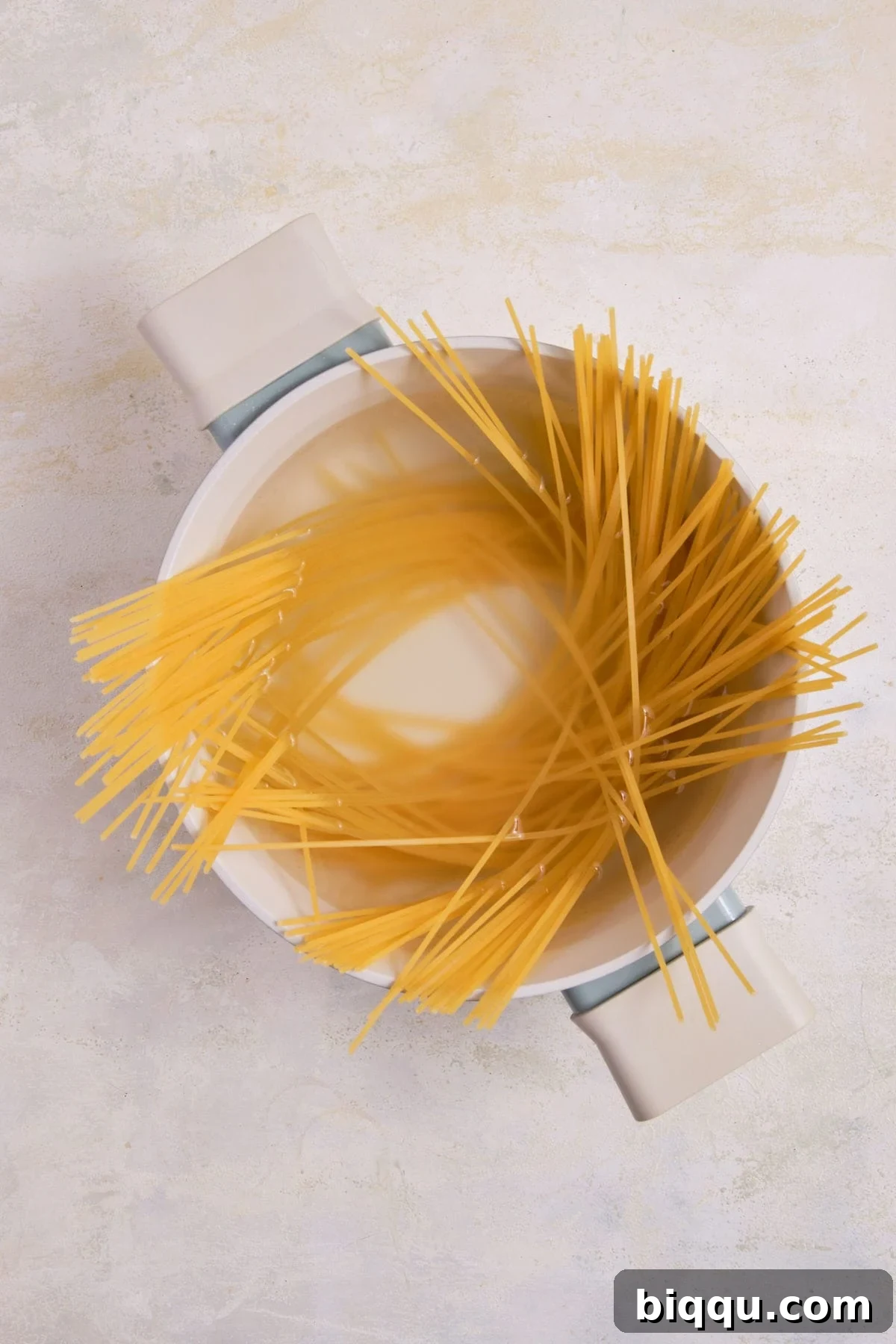 Zesty Lemon Garlic Butter Pasta 9 Spaghetti cooking in a pot of boiling water.
