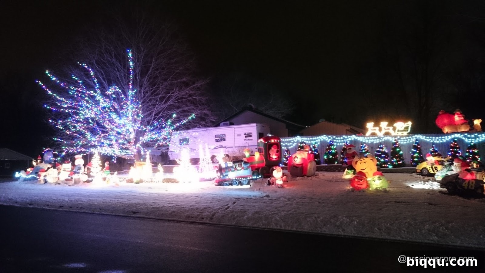 Elaborate Christmas light display on a house, featuring many decorations