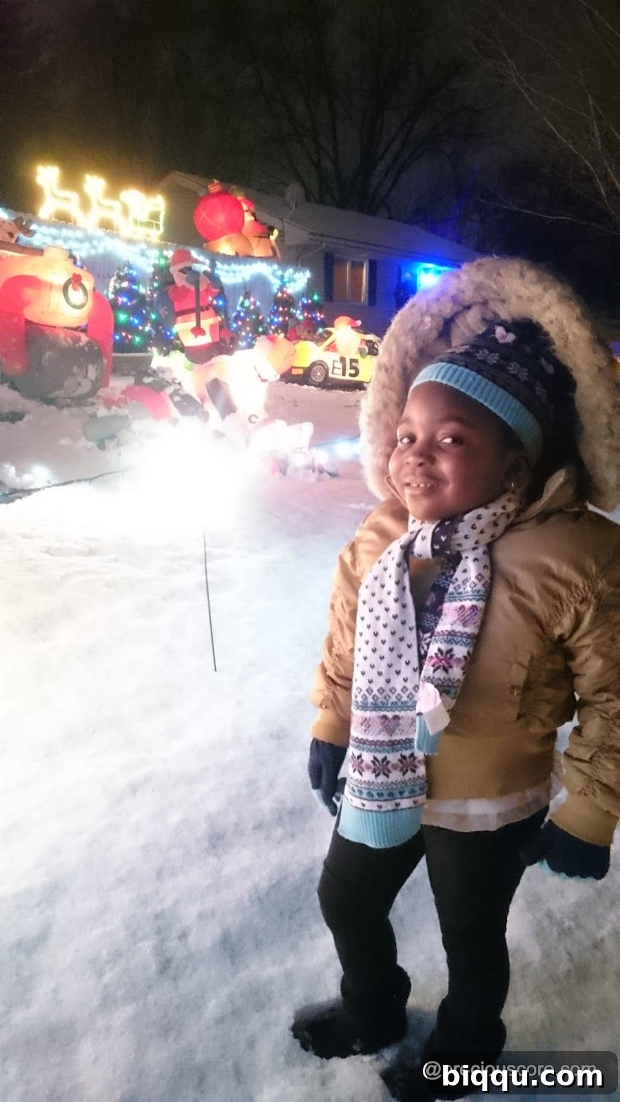 A child smiling brightly against a blurred background of colorful Christmas lights
