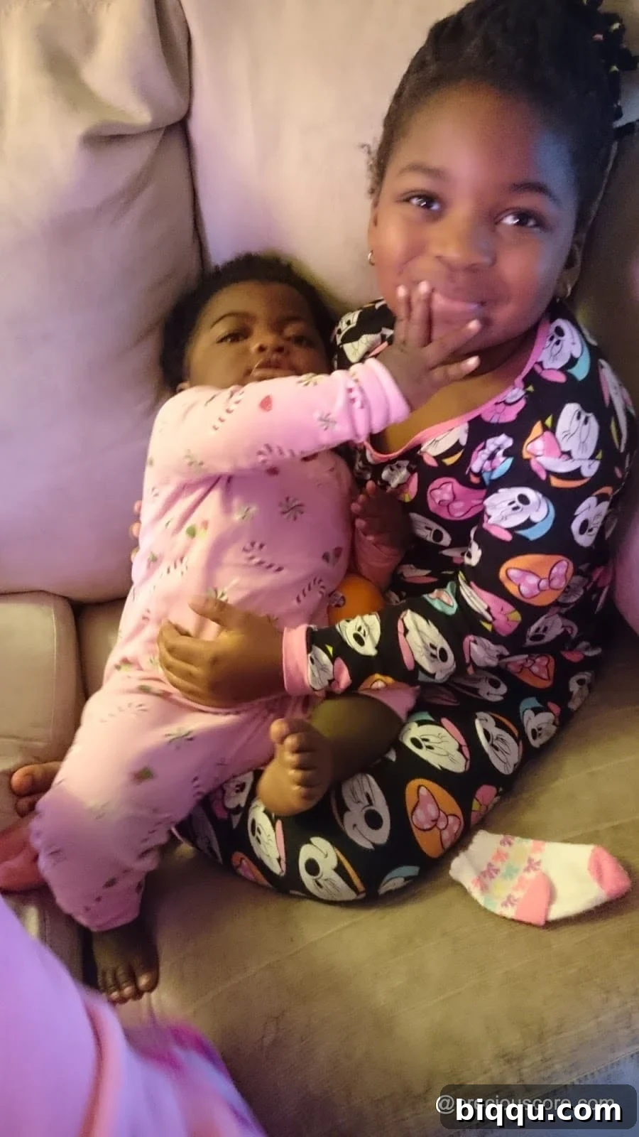 Two children lovingly cuddled up in their pajamas