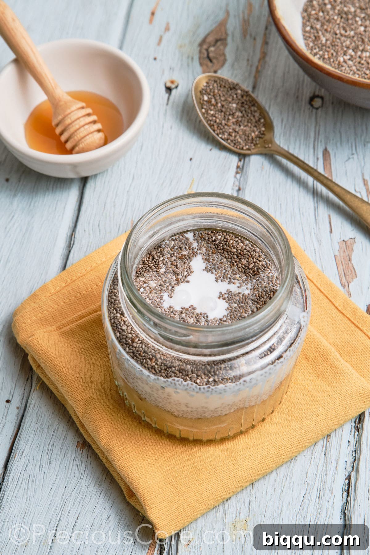The banana chia pudding mixture stirred thoroughly in a glass jar.