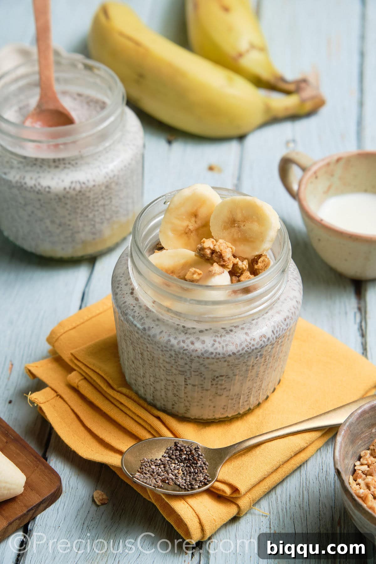 Two glass jars filled with banana chia pudding, ready for chilling.