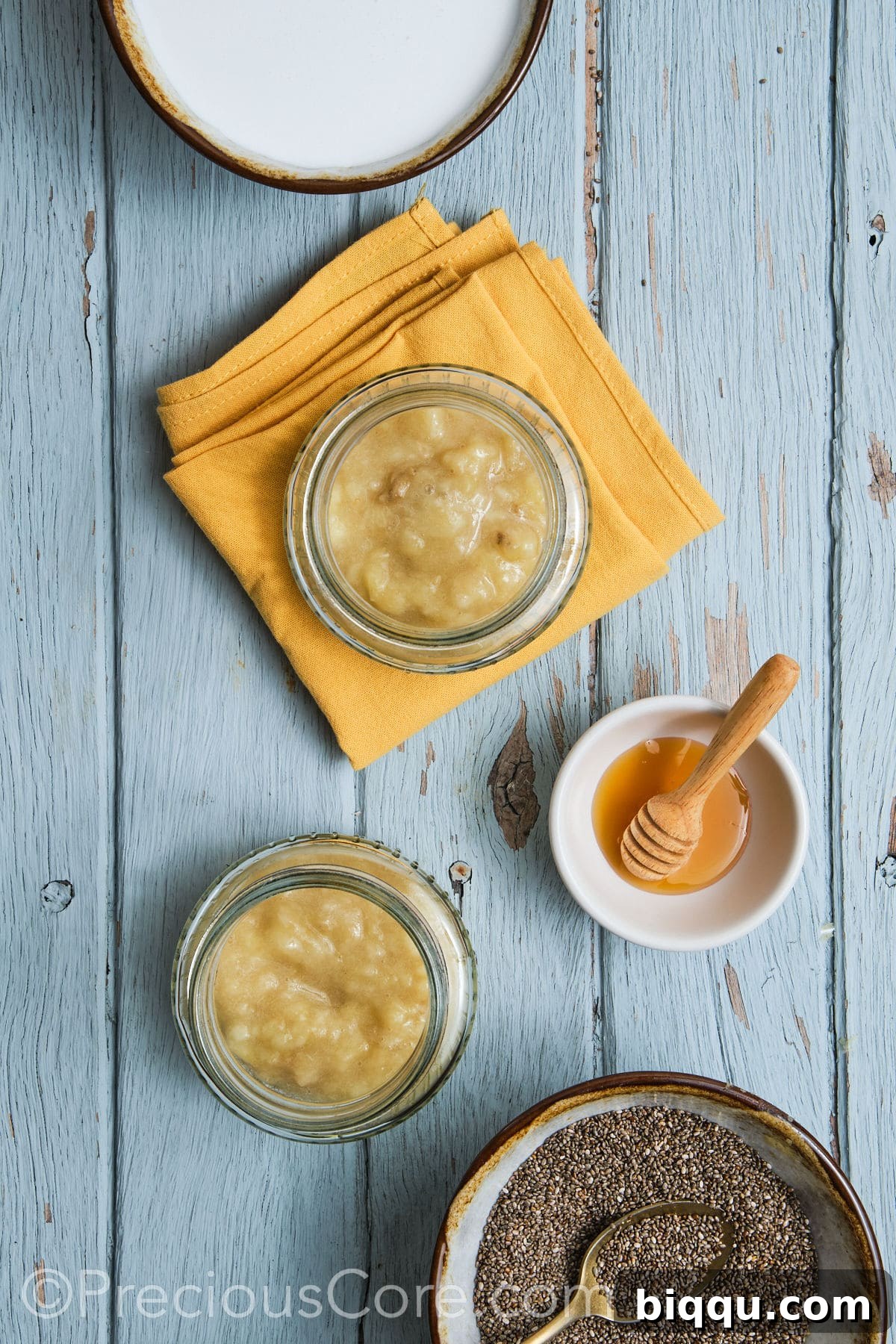 Adding the mashed bananas to glass jars for individual servings.