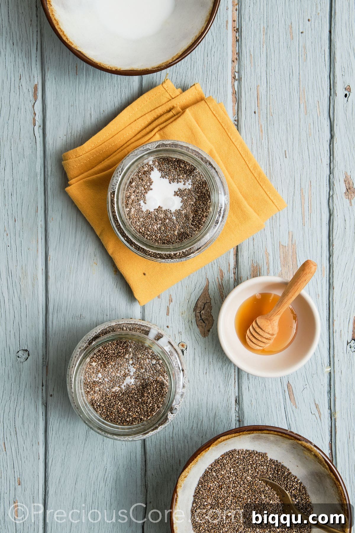 Pouring coconut milk into a glass jar with mashed bananas and other ingredients.