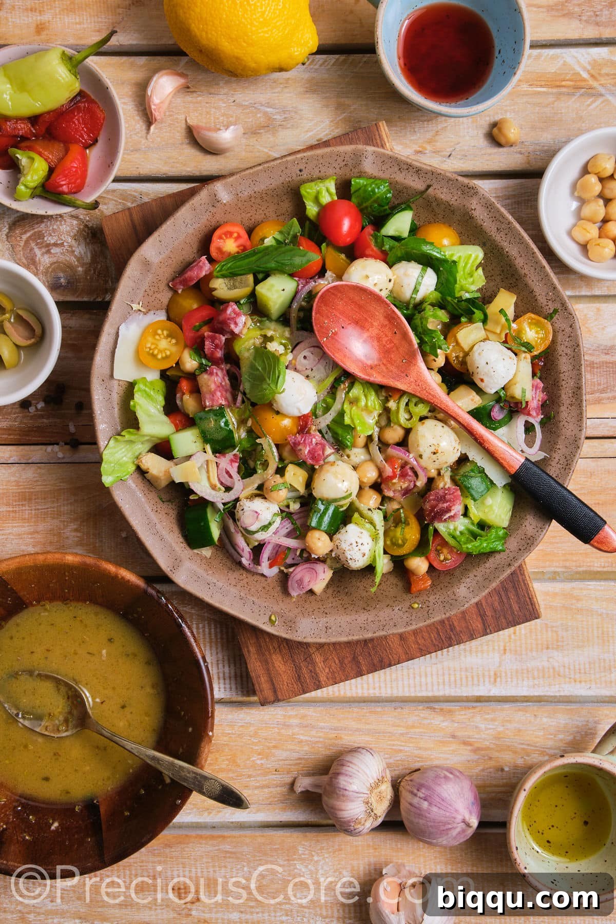A freshly mixed chopped salad, glistening with dressing and ready to be served.