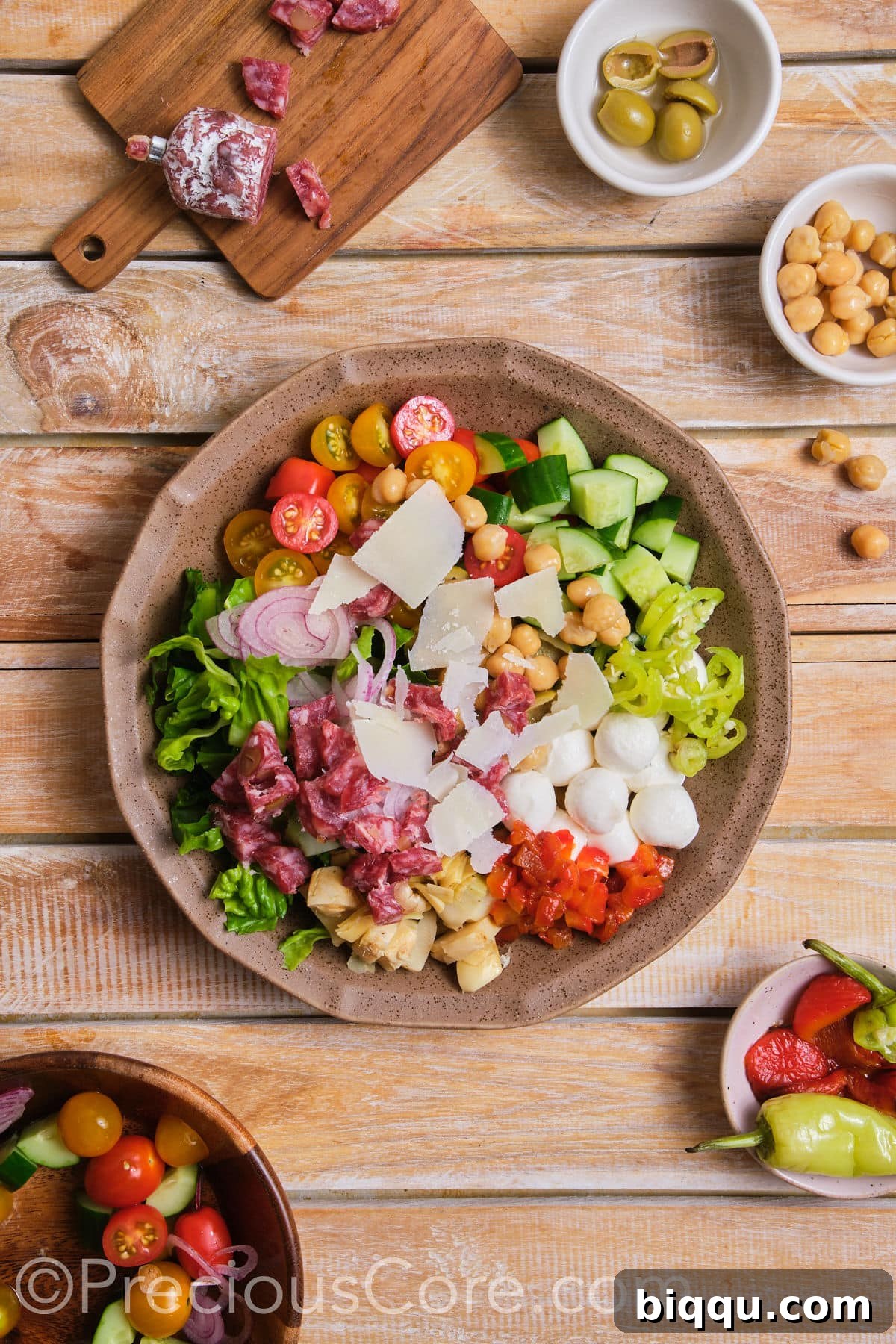 All the vibrant salad ingredients harmoniously placed together in a large mixing bowl.