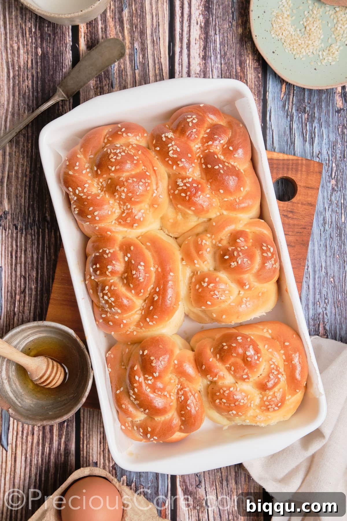 Close-up of baked challah twists on a baking sheet.