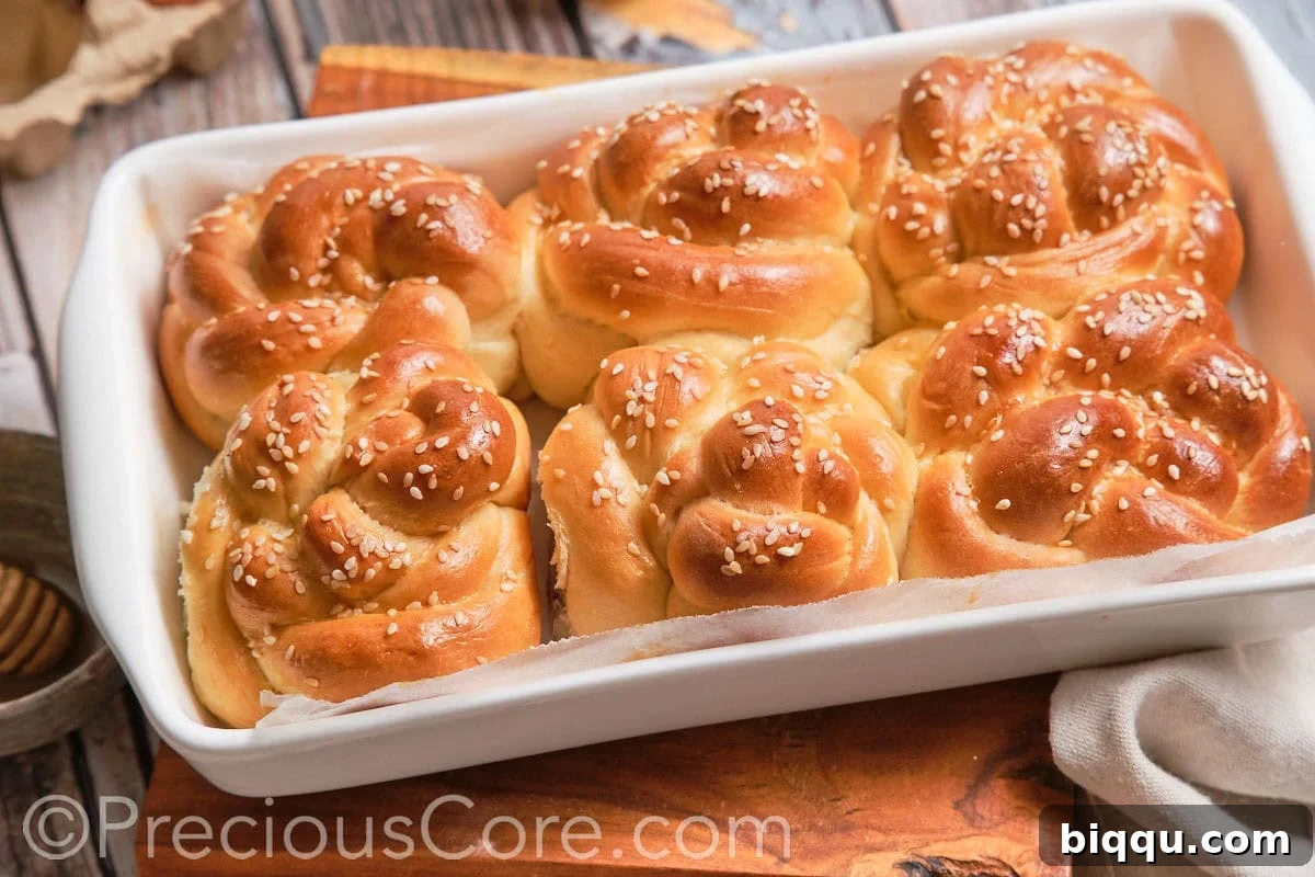 A landscape view of several freshly baked challah dinner rolls arranged beautifully.