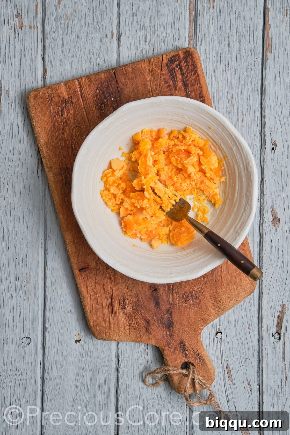Close-up of fluffy, mashed egg yolks in a bowl, ready for mixing with other ingredients.
