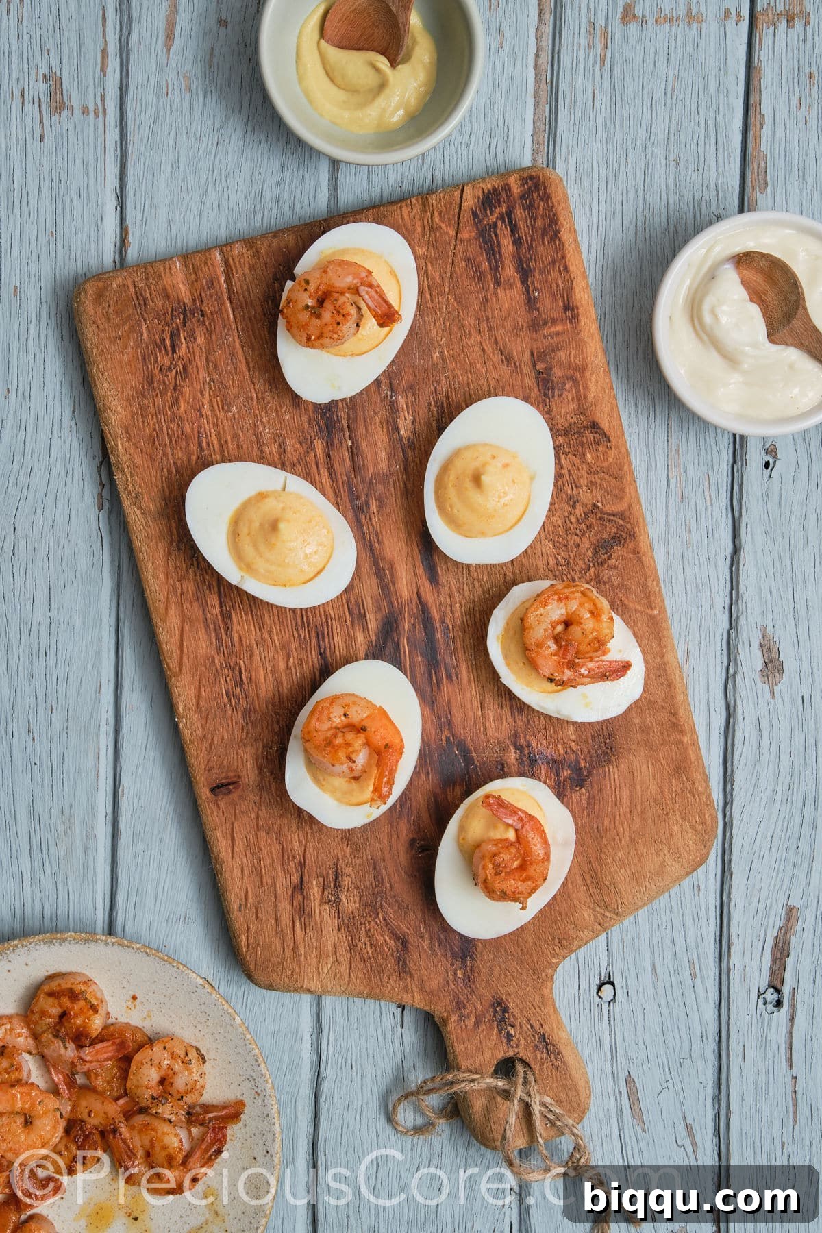 Beautifully filled deviled eggs, each adorned with a perfectly cooked Cajun shrimp.