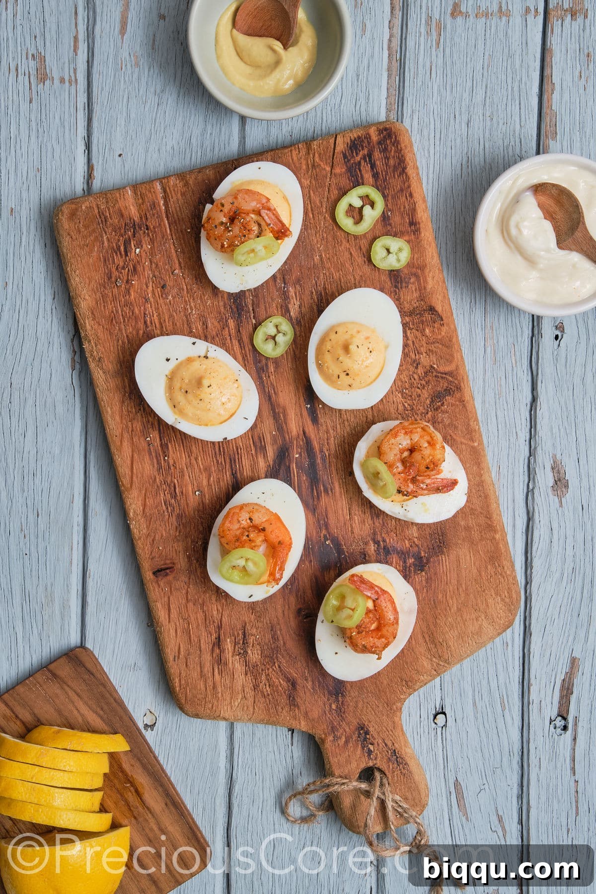 Deviled eggs with Cajun shrimp, now topped with vibrant green chives and a delicate slice of red jalapeno for garnish.