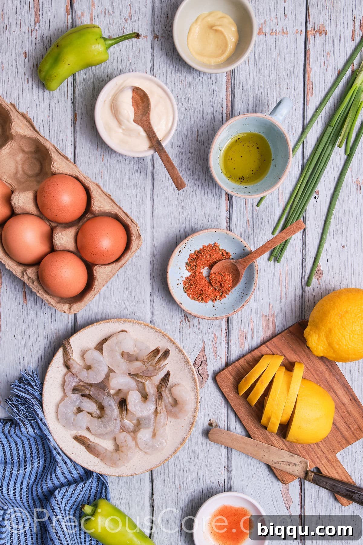 A neatly arranged flat lay of all the fresh ingredients needed for Deviled Eggs with Cajun Shrimp, including eggs, shrimp, spices, and garnishes.