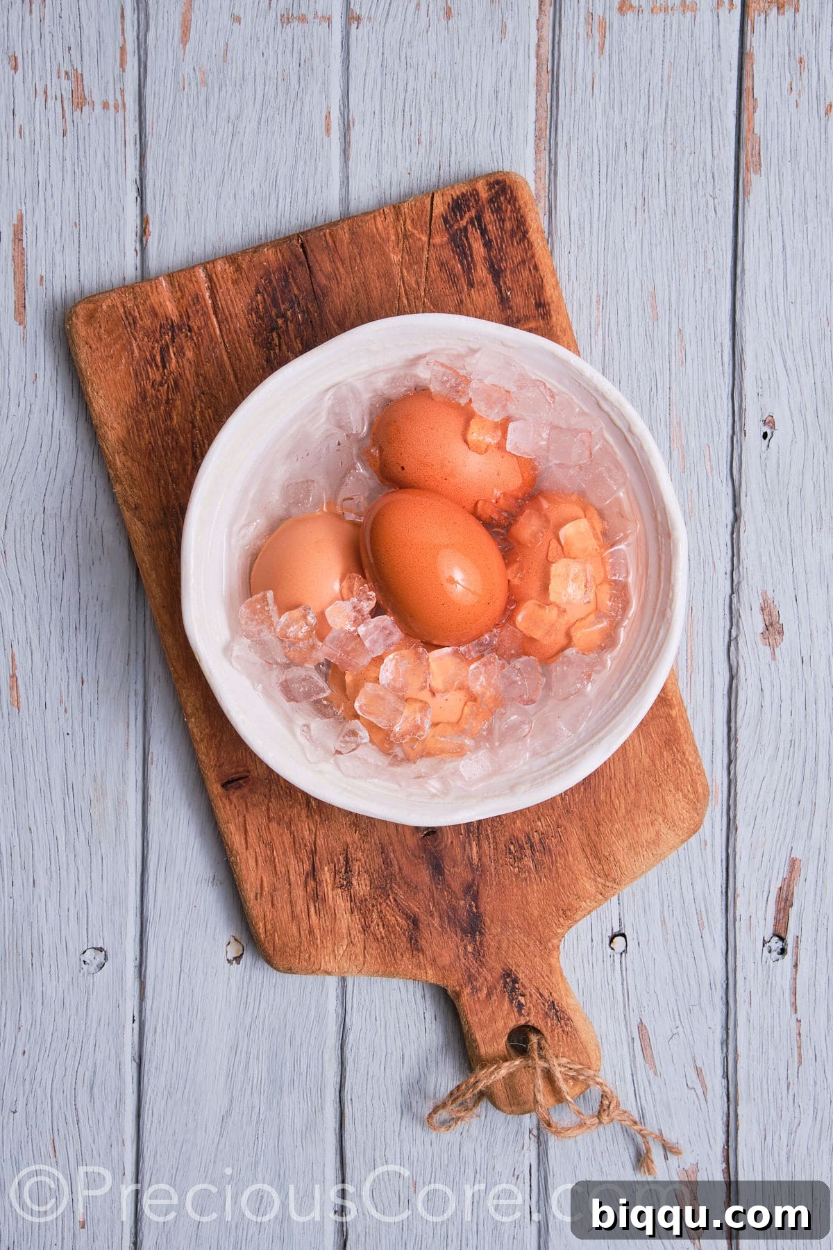 Freshly boiled eggs submerging in a bowl of ice water for a quick cool-down.