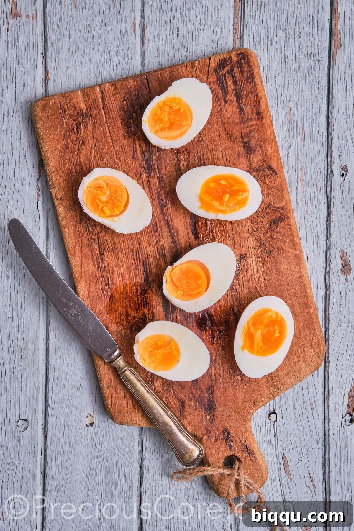 Neatly halved hard-boiled eggs, exposing their perfectly cooked whites and yolks.
