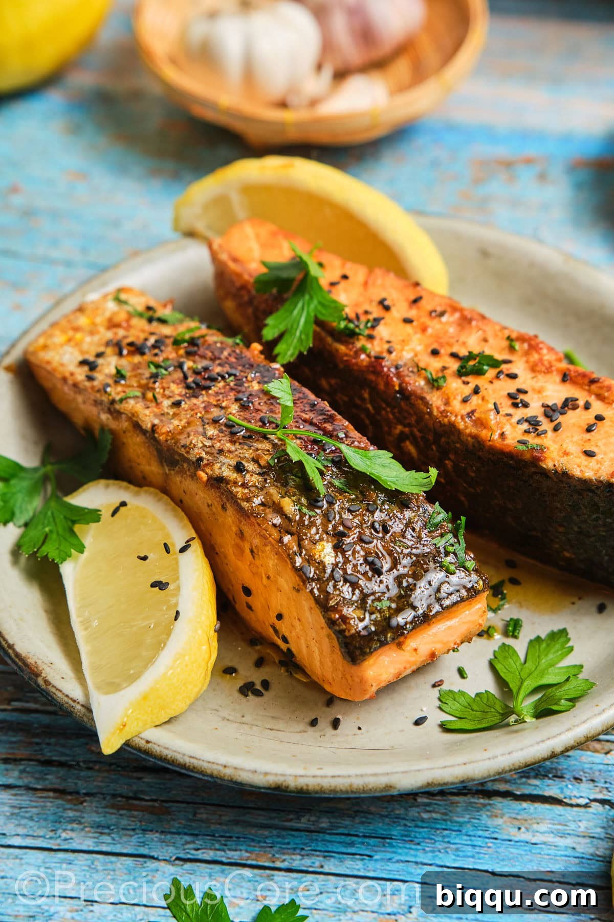 A perfectly cooked Cajun Honey Butter Salmon fillet, garnished with fresh herbs, on a pristine white plate.