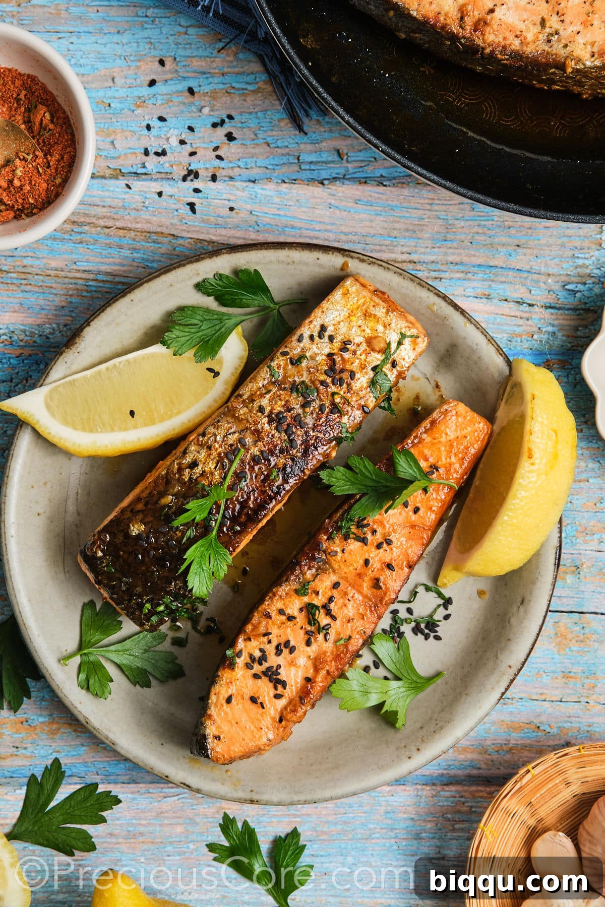 Flaky cooked salmon on a plate, garnished with fresh parsley and a drizzle of honey butter sauce.