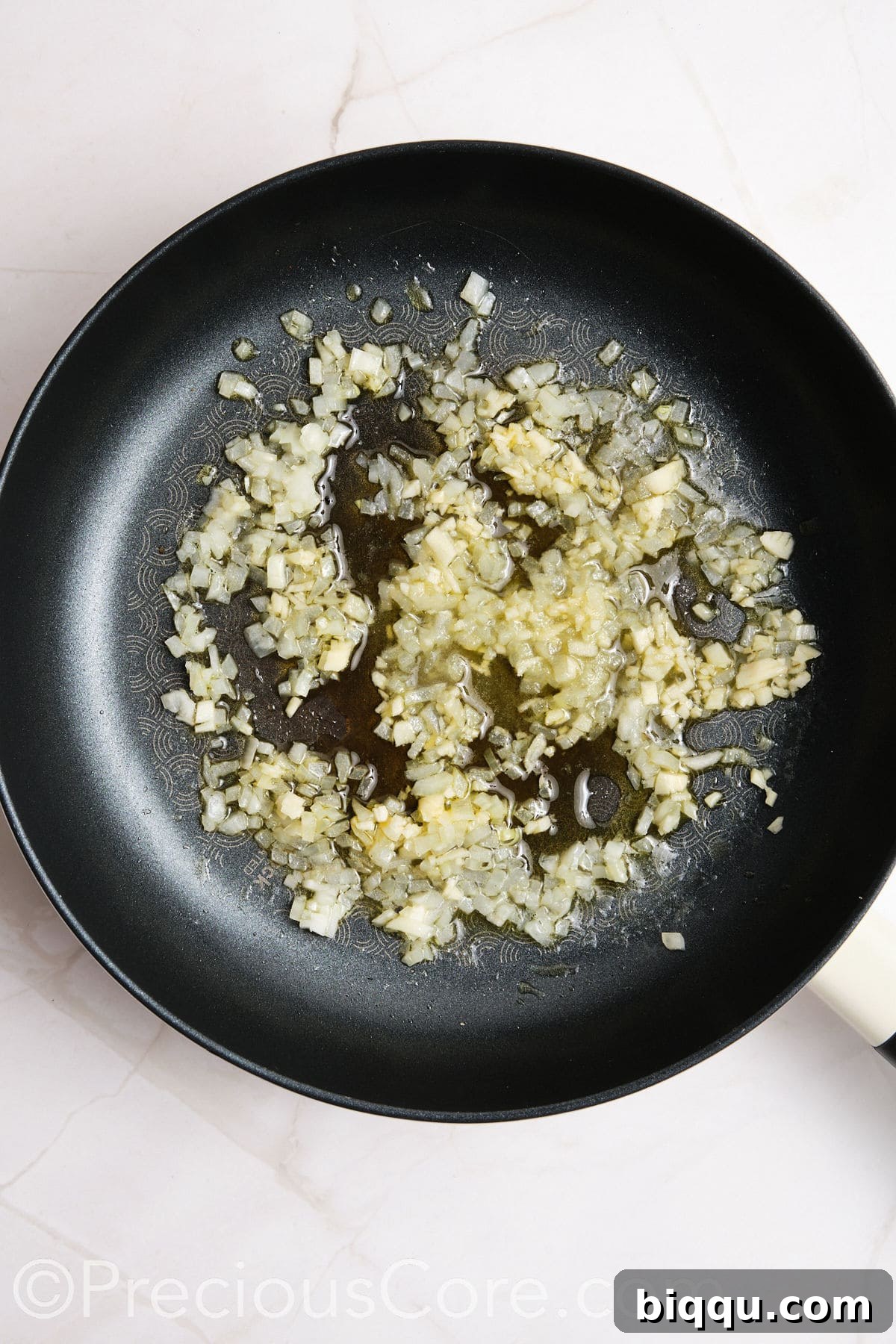Onions and other ingredients cooking in a skillet.