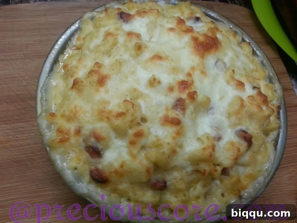 Baked Macaroni and Cheese with sausage and potatoes in a cake pan