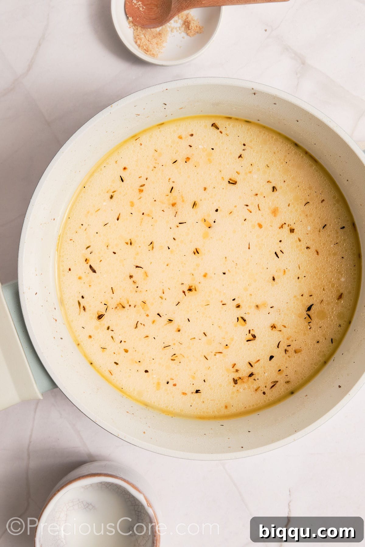 Water and heavy cream added to the pot with sautéed aromatics, ready to be brought to a boil.