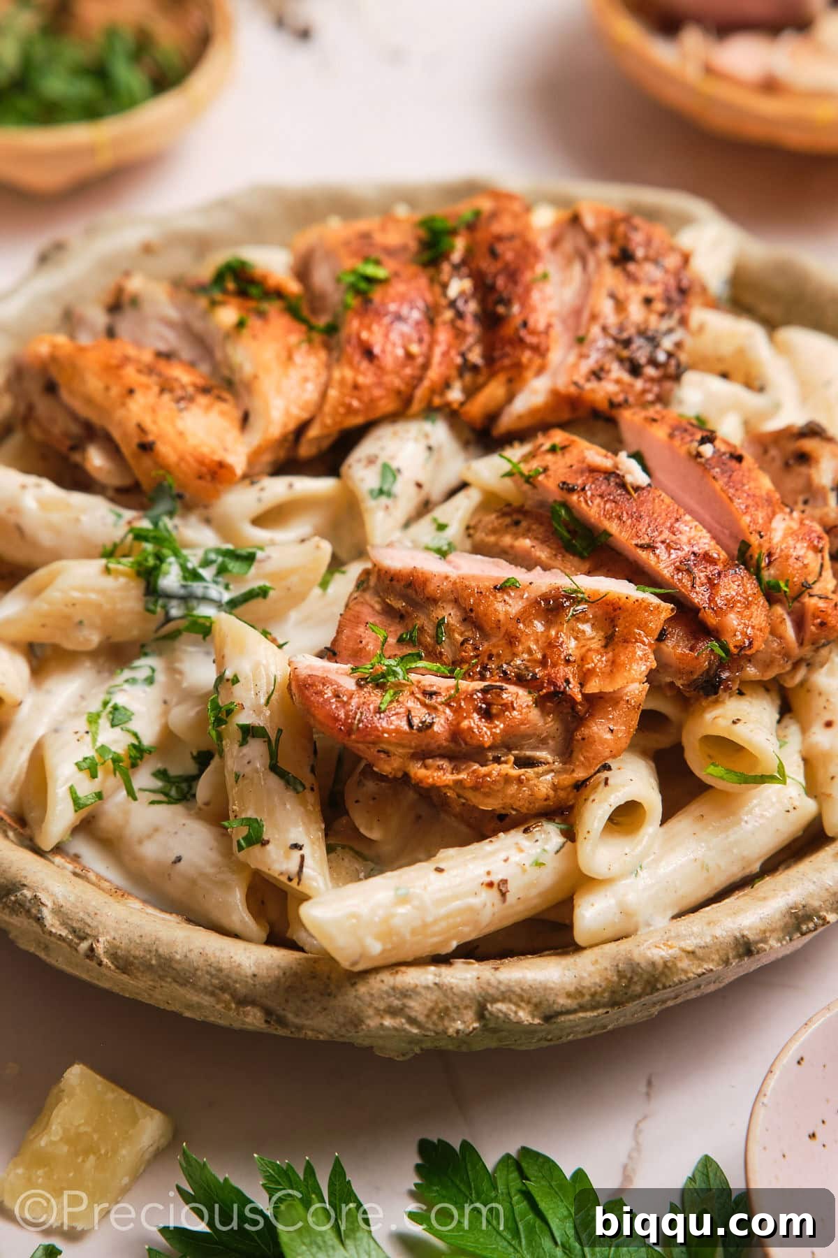 Close-up of a bowl filled with luscious one-pot creamy pasta with chicken pieces.