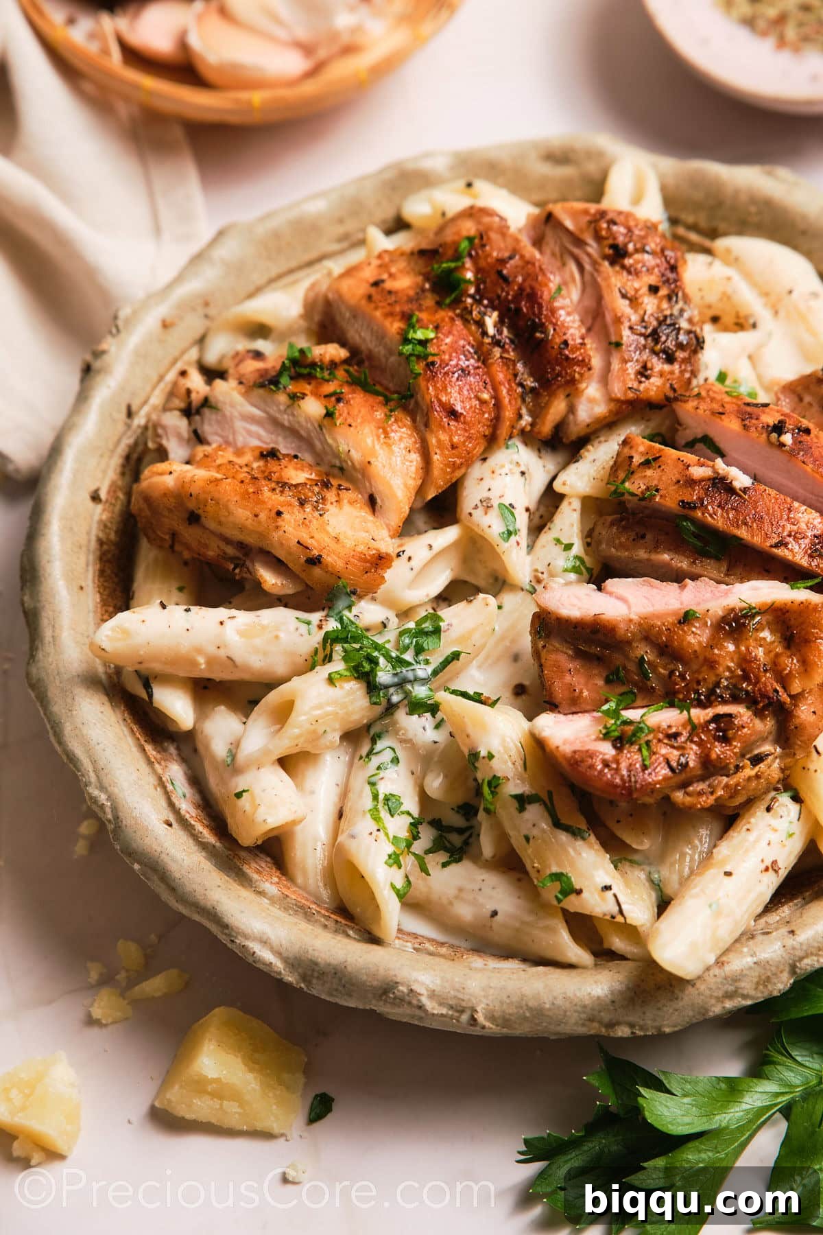 A vibrant close-up shot of a bowl of creamy pasta, highlighting its rich texture and steam.