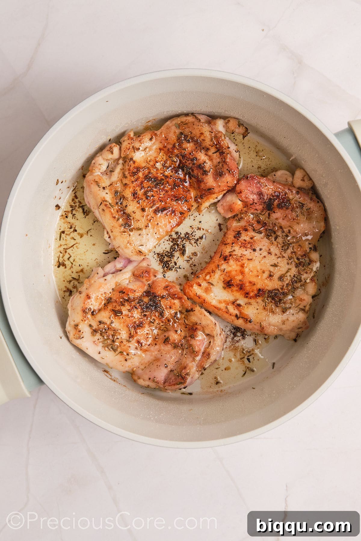 Perfectly browned chicken thighs resting in a pot after searing, ready to be removed.