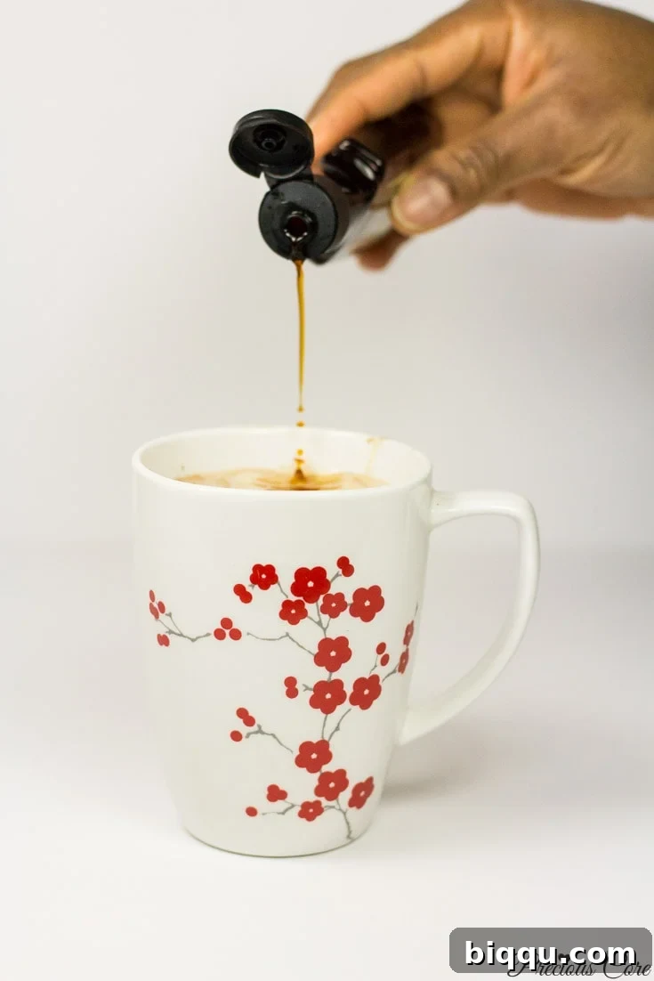 Adding vanilla extract to coconut hot chocolate ingredients to enhance flavor.