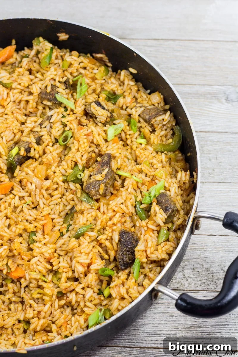 A large pot filled with fragrant Cameroonian Jollof Rice, ready to be served.