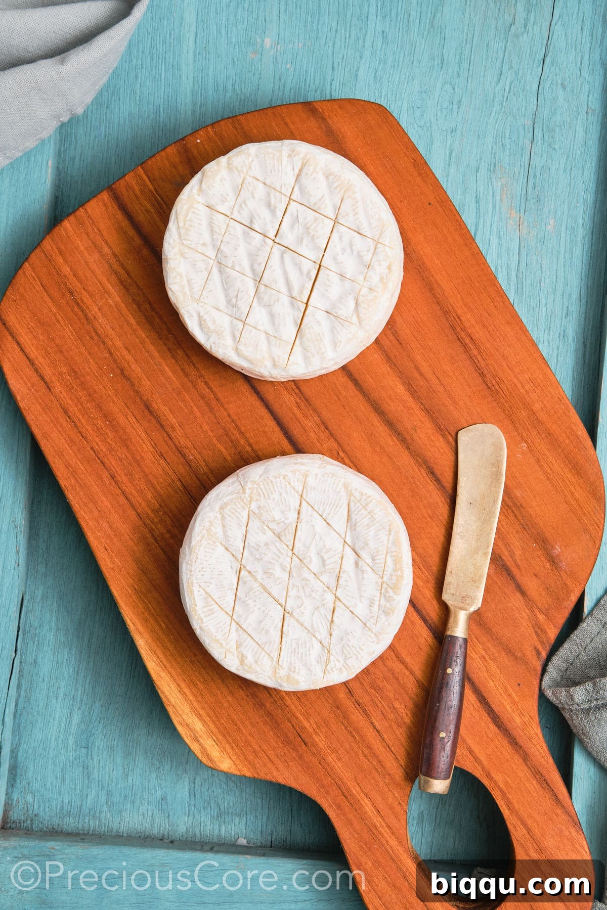 Two rounds of brie scored in a criss cross pattern.